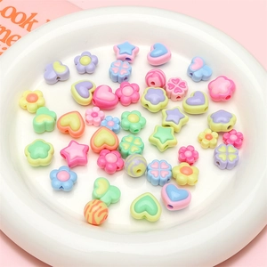 Macro shot of colorful pastel macaron acrylic beads in various flower and heart shapes