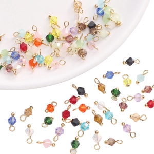 Macro detail of multi-colored bicone crystal glass pendants with gold-plated metal loops