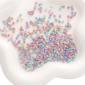 Macro shot of colorful macaron square resin beads for DIY jewelry making in a white bowl