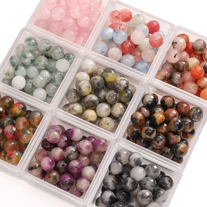 Macro shot of colorful faceted gemstone beads neatly arranged in a clear organizer box