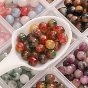 Detailed view of faceted colorful natural stone beads in a ceramic spoon for DIY jewelry