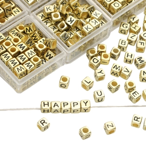 Golden acrylic alphabet beads set in transparent storage box for DIY jewelry making