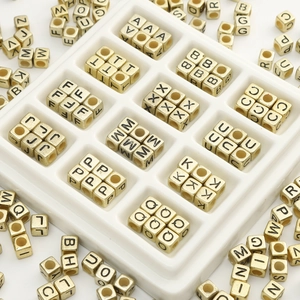 Acrylic alphabet cubes set with gold letters in white tray for DIY jewelry making