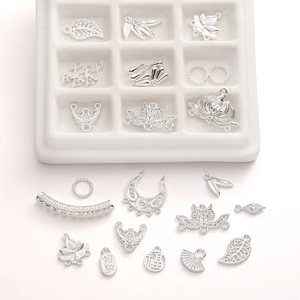 Detail van zilveren holle lotus en gelukskarakter bedeltjes voor DIY sieraden maken
