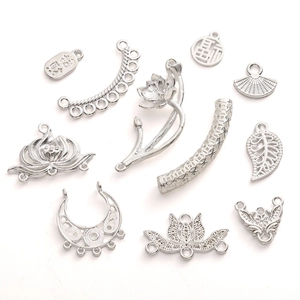 Detailopname van zilveren lotusbedeltjes en metalen accessoires met Chinese tekens