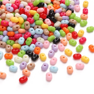 Perline colorate in acrilico a forma di arachide per gioielli fai-da-te su sfondo bianco