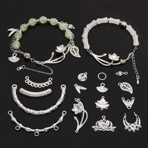 DIY sieraden kit met groene kralen, lotus bedeltjes en holle bladeren op zwart glas