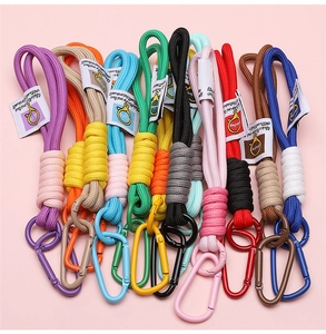 Détail de porte-clés en corde tressée colorée avec mousqueton métal et étiquette déco