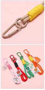Gros plan de porte-clés en corde tressée colorée avec mousqueton et pendentifs divers