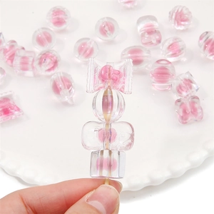 Vue macro de perles en acrylique rose en forme de cœur et bonbon pour bijoux DIY