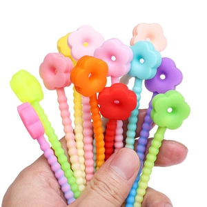 Colorful silicone flower stir sticks and straw toppers in various macaron shades