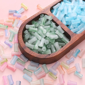 Dettaglio macro di perle in vetro a forma di bambù color pastello per gioielli DIY