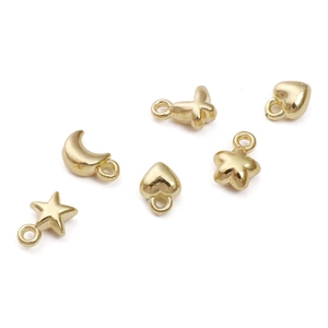 Detailopname van gouden maan-, hart- en sterbedeltjes voor DIY-sieradenaccessoires