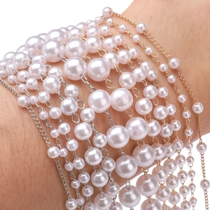 Dettaglio macro del bracciale multistrato in perle ABS con catene in oro e argento