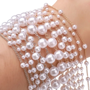 Primo piano dettagliato del bracciale multistrato di perle ABS con catene oro e argento