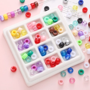 Colorful acrylic barrel beads in a 12-grid storage box for DIY jewelry making
