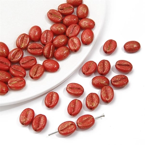 Macro-opname van rode koffieboon acrylkralen met gouden textuur voor DIY-sieraden