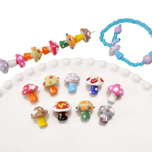 Macro view of colorful hand-painted glass mushroom beads with dots for DIY jewelry