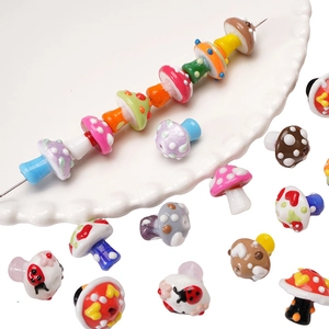 Macro shot of colorful hand-painted mushroom and ladybug glass beads for DIY jewelry making