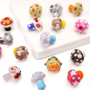 Macro shot of colorful handmade mushroom glass beads with various patterns and heart shapes