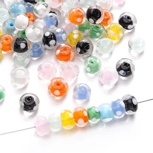 Primer plano de cuentas de vidrio hechas a mano con lunares blancos para joyería artesanal
