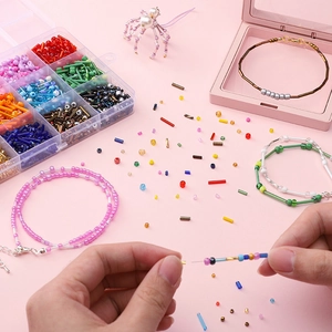 12-grid DIY jewelry kit with colorful seed beads, tubes, and tools for making bracelets