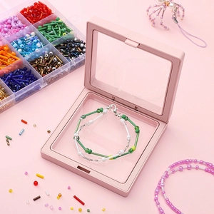 Pink PE film floating jewelry box displaying DIY green and white beaded bracelets