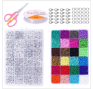 Vista macro del kit de joyería DIY con cuentas de letras, tijeras y cordón elástico para pulseras