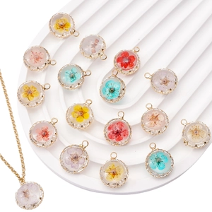 Detailed close-up of handmade round 18K gold-plated dried flower pendants and necklaces