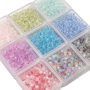 Macro view of assorted translucent glass abacus beads in 9-grid organizer for DIY crafts