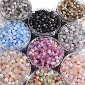 Macro shot of colorful resin cat-eye beads in transparent containers for DIY jewelry
