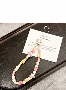 Detailaufnahme einer Handy-Perlenkette mit einem handbemalten rosa Keramikvogel Anhänger