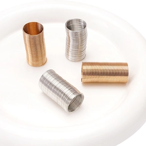 Gold- und Silberfarbene Spiraldrahtringe für DIY-Schmuck auf weißem Keramiktablett