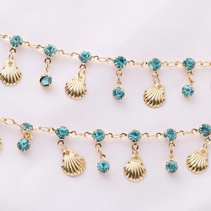 Detailed close-up of golden shell chain with turquoise stones for DIY jewelry making