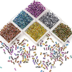 Macro view of colorful 4x5mm cylindrical glass seed beads in transparent storage boxes