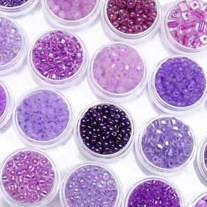 Assortimento di perline di vetro viola in contenitori per gioielli fai da te