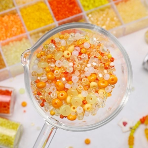 Vue macro de perles de rocaille orange vif dans un gobelet pour bijoux artisanaux