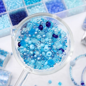 Makroaufnahme himmelblauer Glasperlen in verschiedenen Oberflächen für DIY-Schmuck