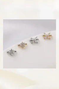 Vue macro de perles intercalaires fleur à quatre pétales dorées 14K avec détails cristal