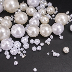 Macro view of white and beige ABS pearl beads for DIY jewelry making in various sizes