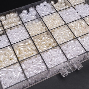 Macro view of white and cream ABS faux pearls organized in a 24-compartment storage box