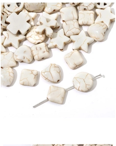Détail macro de perles en howlite blanche en forme d'étoile et de cœur marbré