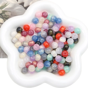 Mix of colorful 11x8mm pearlescent resin beads for DIY jewelry making in a white tray