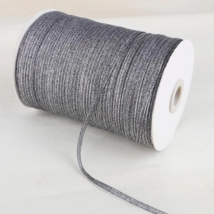 Macro detail of metallic silver glitter ribbon roll for DIY gift wrapping and hair accessories