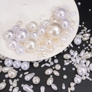Close-up of mixed ivory faux pearls in round, oval and teardrop shapes for jewelry DIY