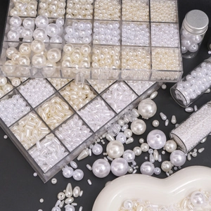 Assorted beige and white faux pearls in various shapes with storage box and glass bottle