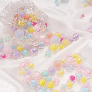 Dettaglio di perle acriliche colorate opache e iridescenti per gioielli fai-da-te