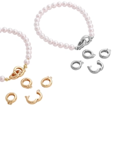 Dettaglio di bracciali di perle rosa chiaro con grandi chiusure a molla in oro e argento