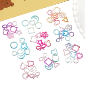 Macro shot of colorful gradient iridescent faux pearl charms in heart and star shapes