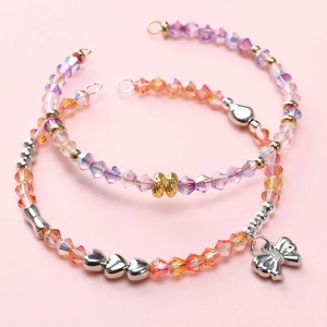 Detalle de pulseras de cuentas de vidrio Aurora 4mm con corazones y dije de lazo